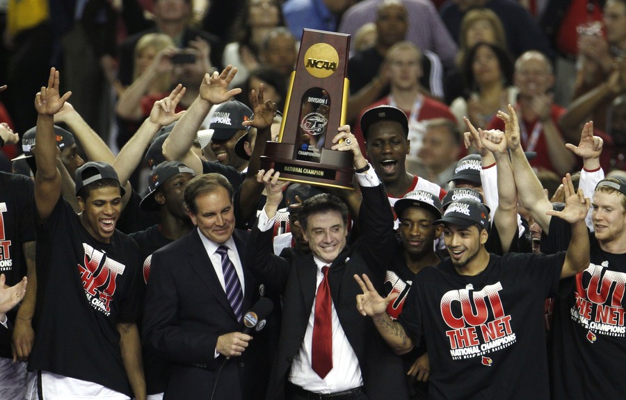 Louisville Cardinals head coach Rick Pitino holds up the championship trophy with his team after defeating the Michigan Wolverines in their NCAA men's Final Four championship basketball game in Atlanta
